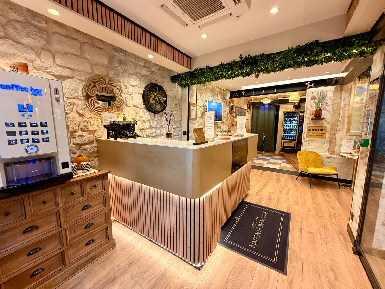 La réception de l’Hôtel Nation Montmartre, son comptoir éclairé et son hall